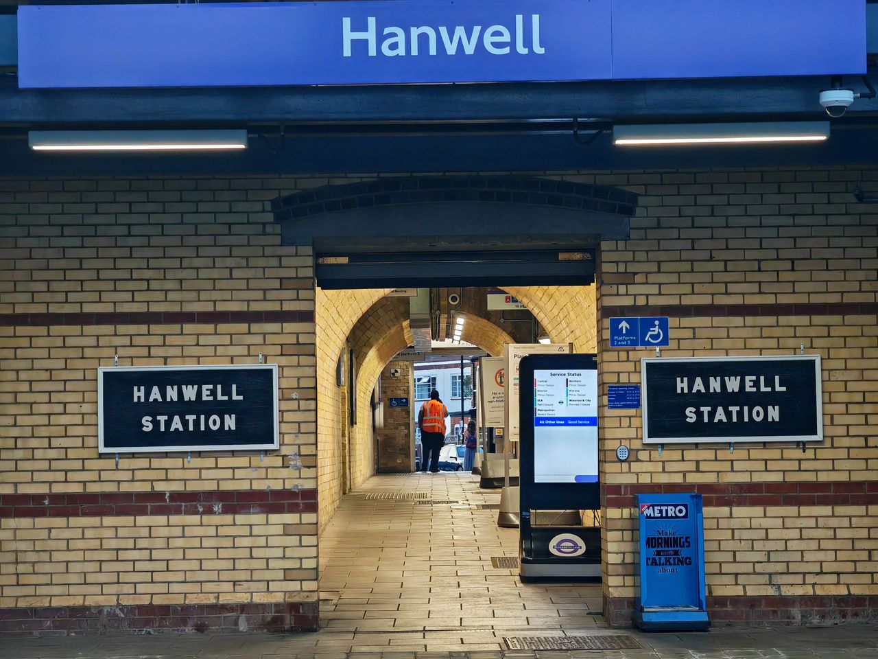 The arched entrance to Hanwell station with Hanwell Station name boards on yellow brick