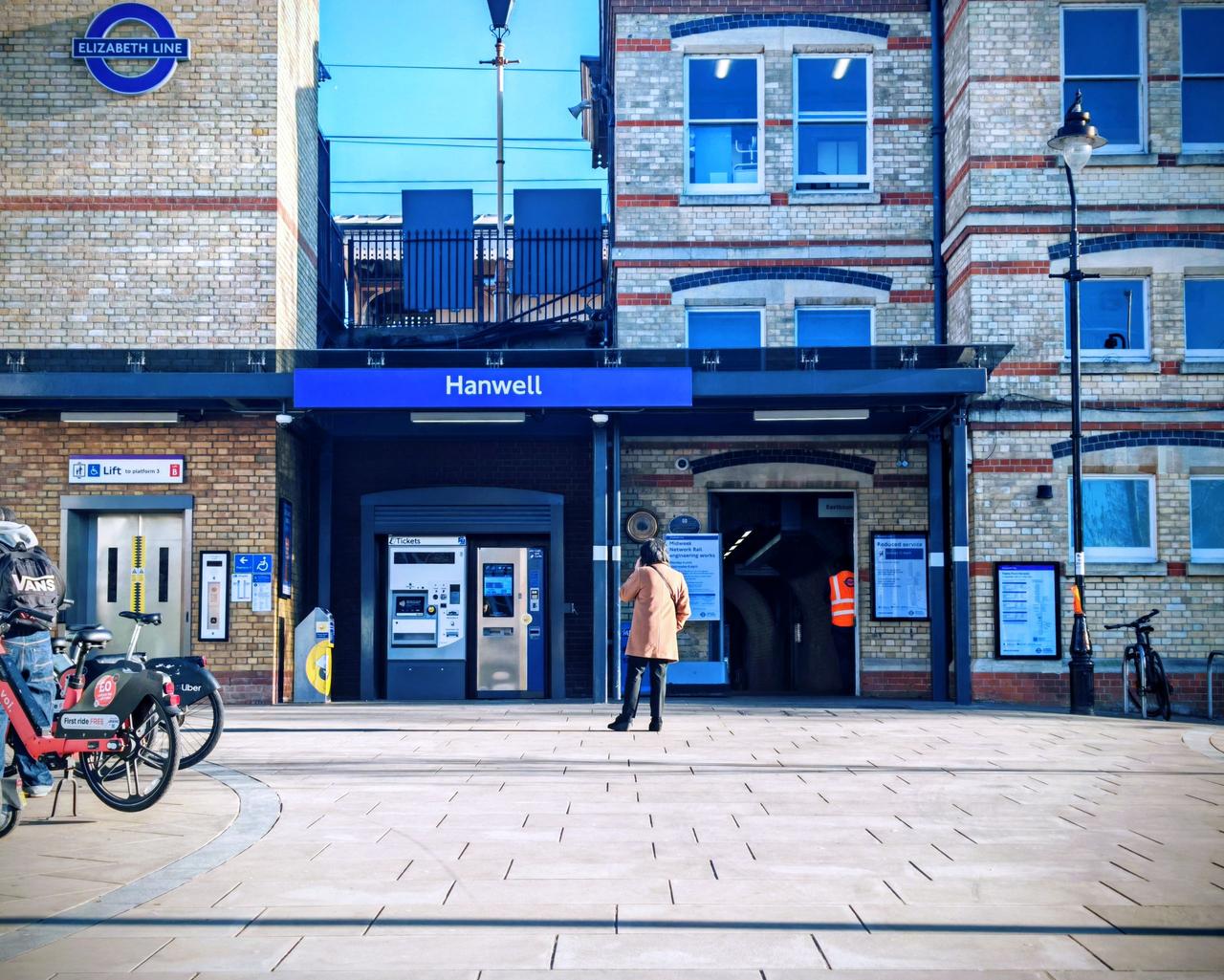 Hanwell station's brick front building with the Elizabeth line sign and bicycles parked outside